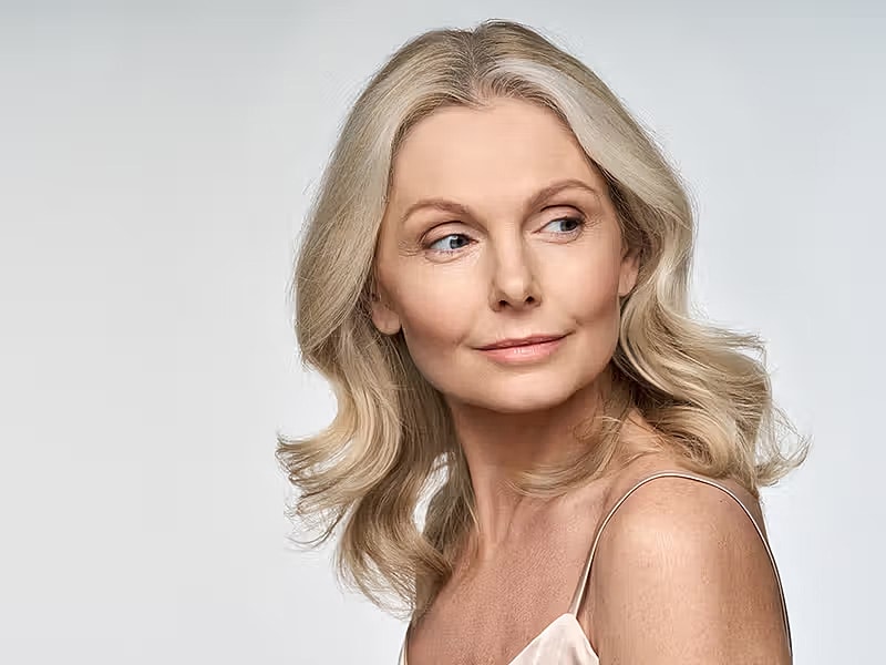 Woman with wavy blonde hair looking over shoulder.