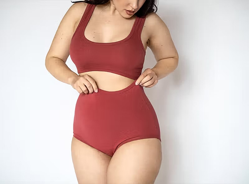 Model in red activewear posing for the camera.