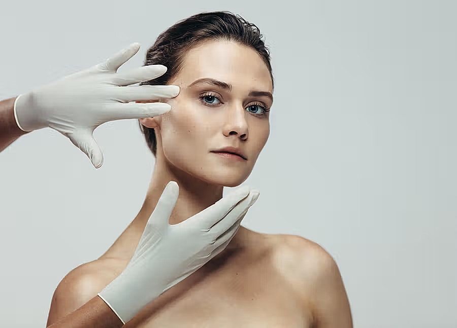 Beauty treatment with gloved hands on model.