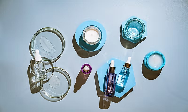 Various skincare products on a blue background.