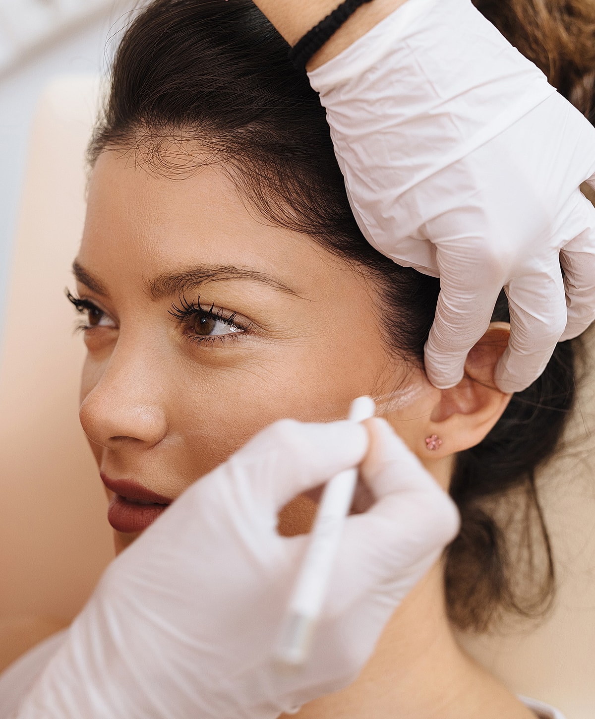 Beauty treatment application on a woman's face.