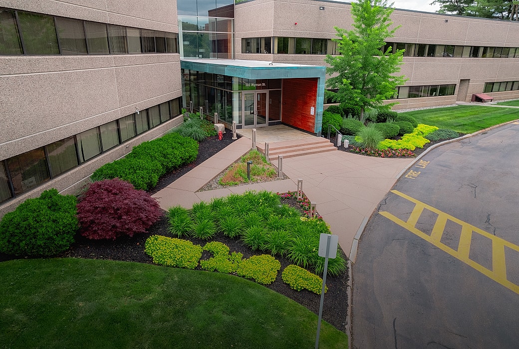 Office building entrance with landscaped garden.