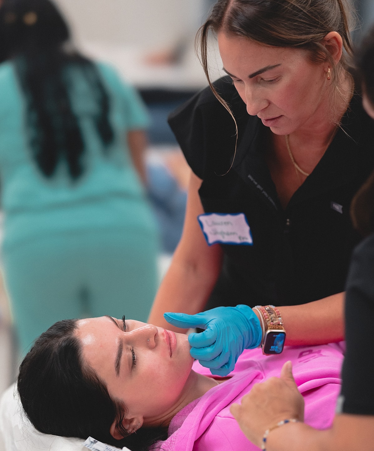 Women applying skincare treatments in a clinic.