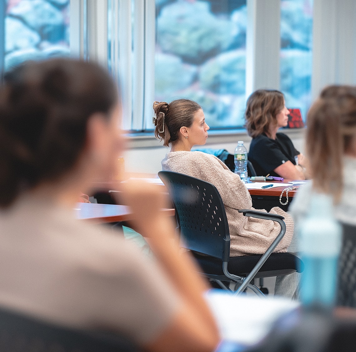 Students attentively listening in a classroom setting.