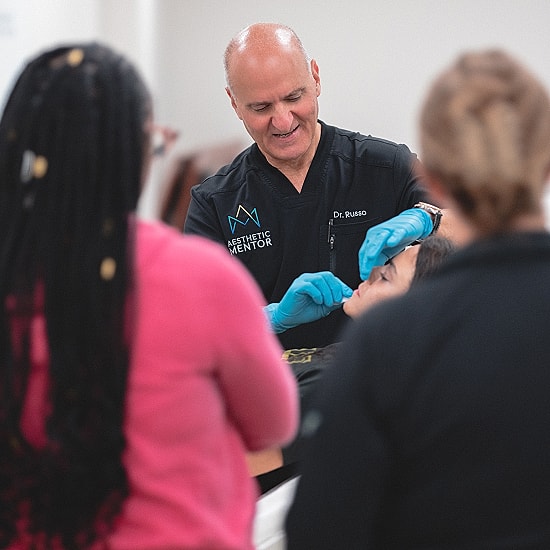 Instructor demonstrating aesthetic procedures to students.