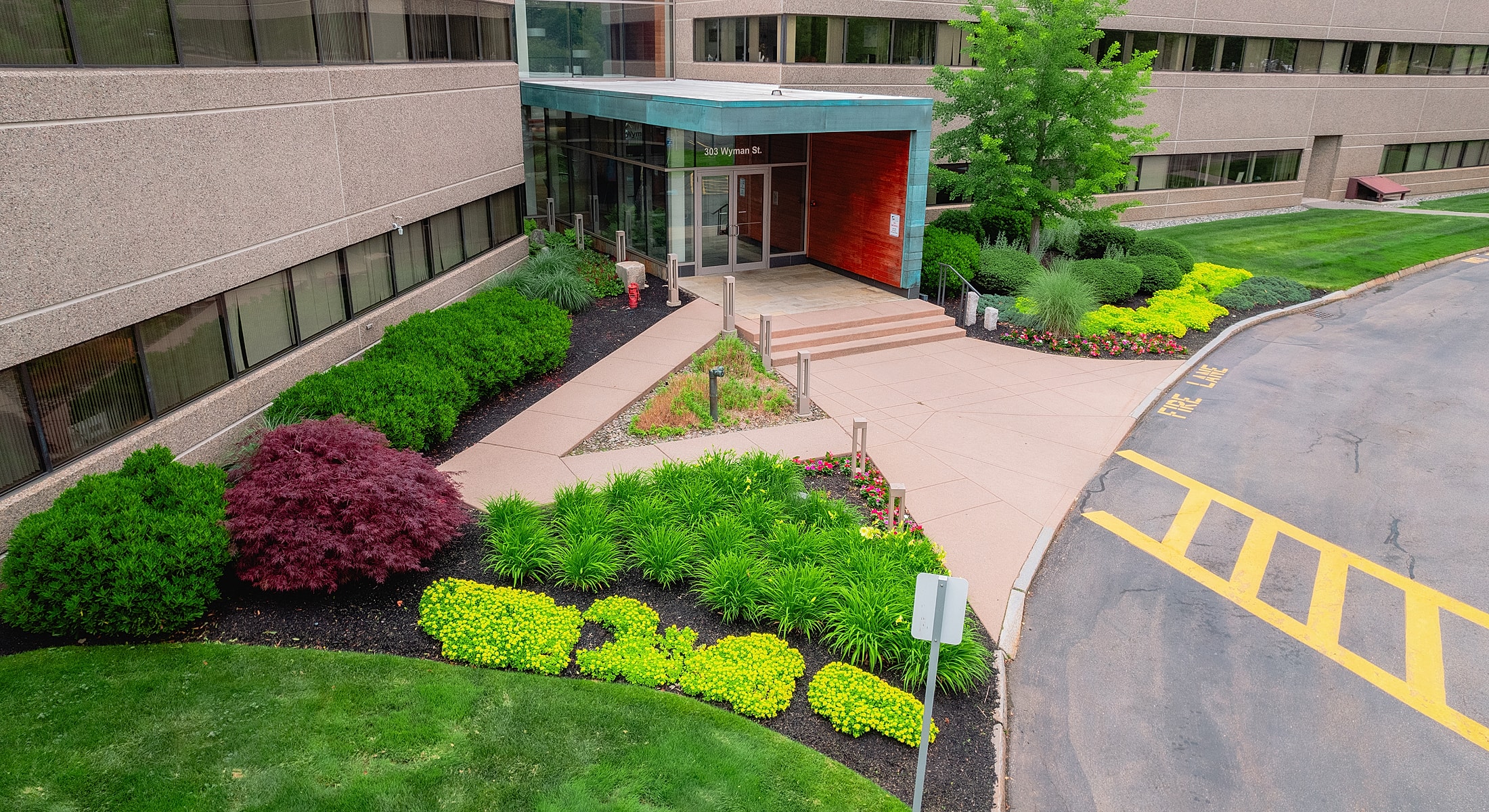 Office building entrance with landscaped gardens.