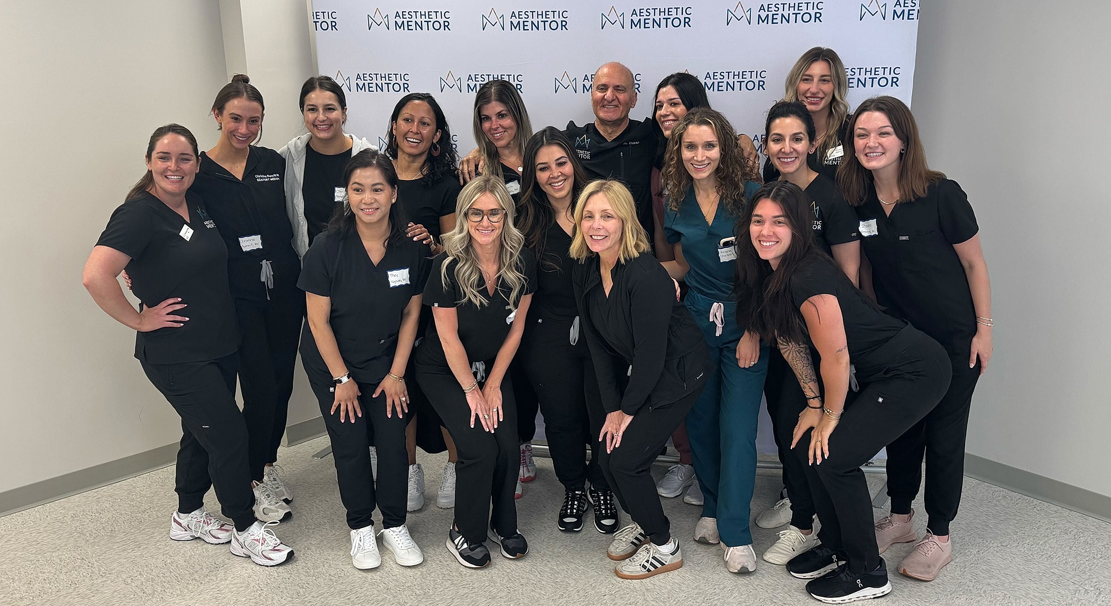 Two professionals smiling together against a dark background.